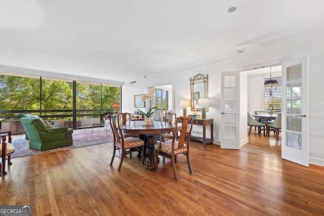 2660 Peachtree Rd Unit 7F, Atlanta, GA 30305 - dining area with crown molding, baseboards, plenty of natural light, and wood finished floors