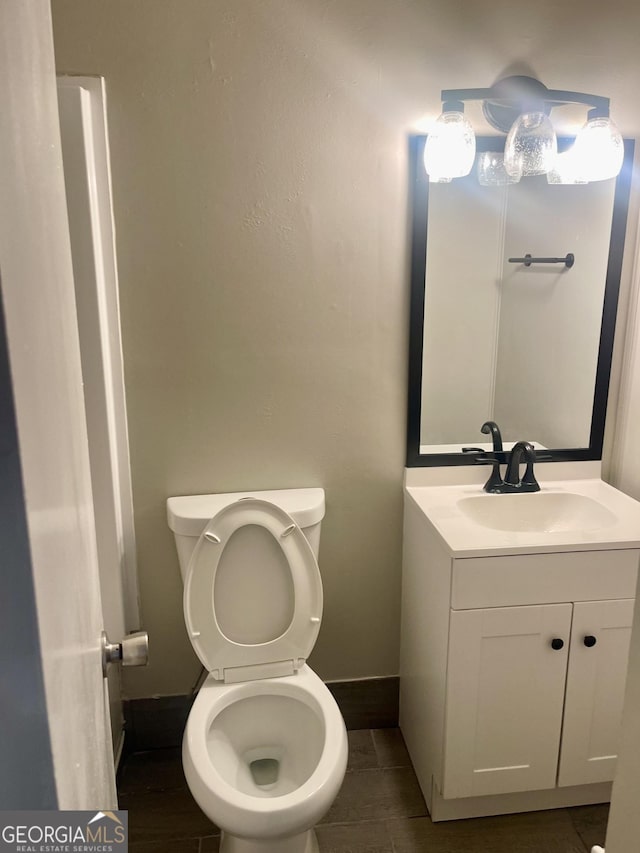bathroom featuring vanity, baseboards, and toilet