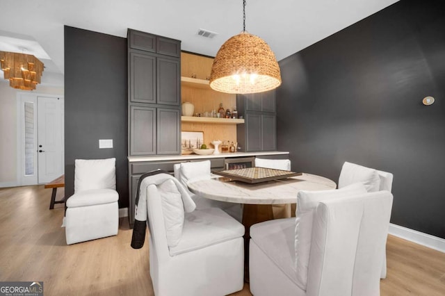 dining room with baseboards, light wood-style flooring, and visible vents