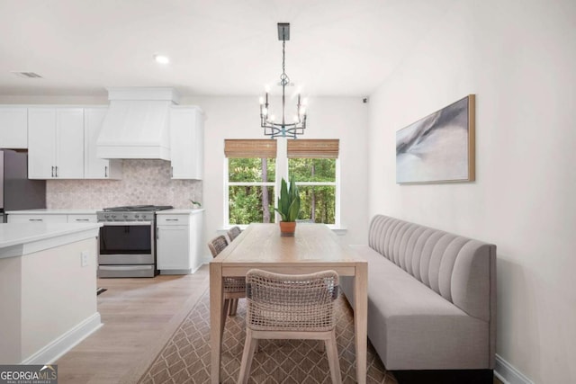 dining room featuring visible vents, baseboards, light wood finished floors, an inviting chandelier, and recessed lighting