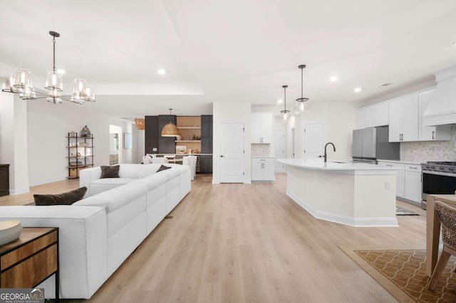 living area with recessed lighting, light wood finished floors, and a chandelier