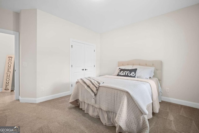 carpeted bedroom featuring baseboards and a closet