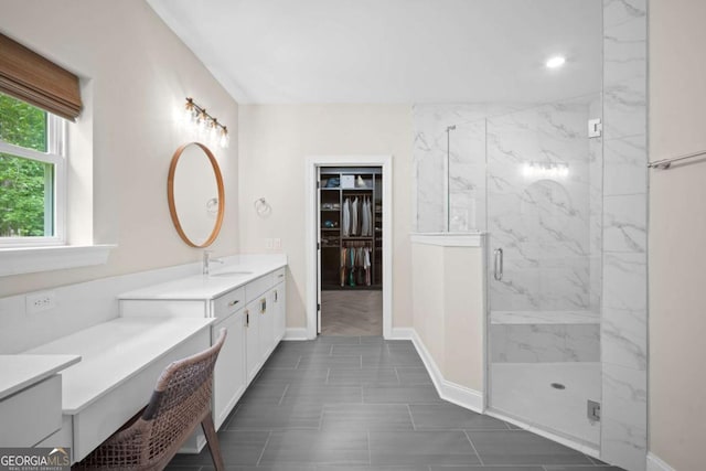 full bath with baseboards, a spacious closet, a marble finish shower, and vanity