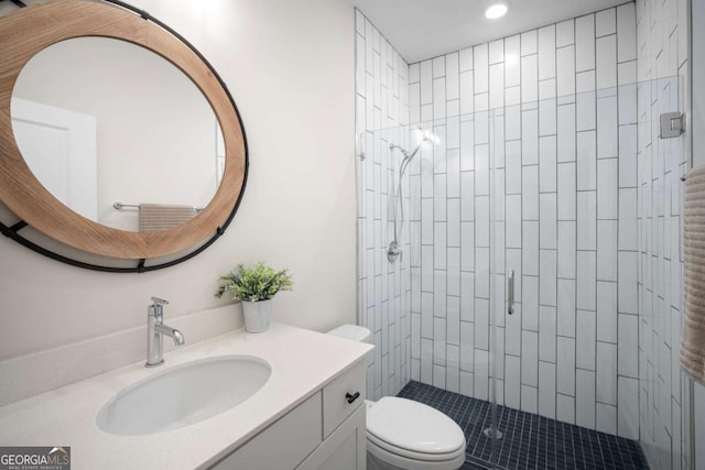 bathroom featuring toilet, recessed lighting, a shower stall, and vanity
