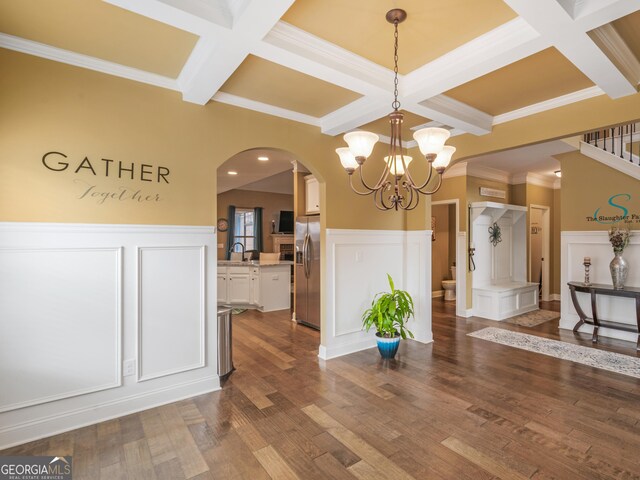 unfurnished dining area featuring a decorative wall, beamed ceiling, coffered ceiling, and arched walkways