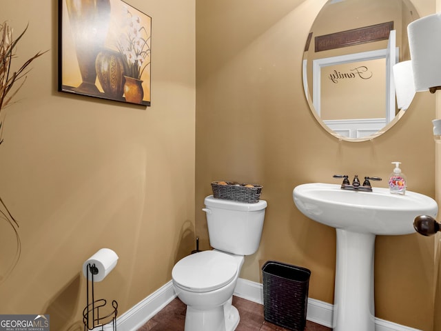 bathroom with baseboards and toilet
