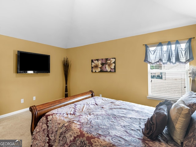 carpeted bedroom featuring baseboards and vaulted ceiling