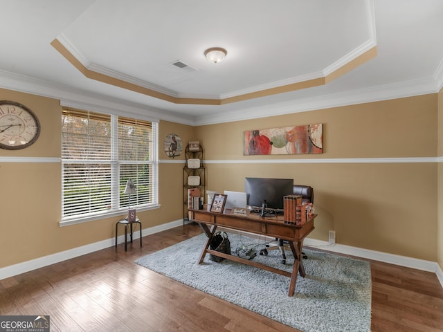 home office with visible vents, crown molding, wood finished floors, a raised ceiling, and baseboards