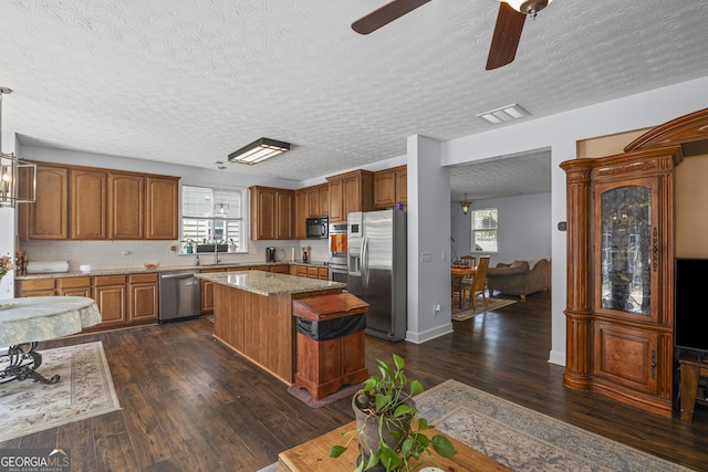 35 Timber Ln, Newnan, GA 30265 - kitchen featuring appliances with stainless steel finishes, a center island, ceiling fan, a textured ceiling, and dark wood-type flooring