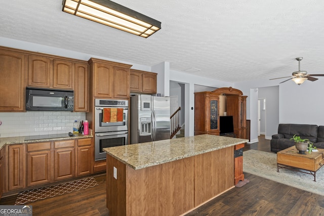 35 Timber Ln, Newnan, GA 30265 - kitchen featuring black appliances, dark wood finished floors, a center island, light stone countertops, and a ceiling fan