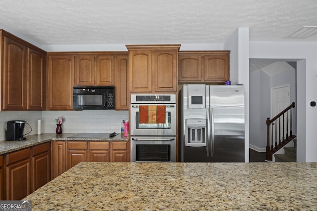 35 Timber Ln, Newnan, GA 30265 - kitchen with black appliances, light stone countertops, backsplash, a textured ceiling, and brown cabinetry