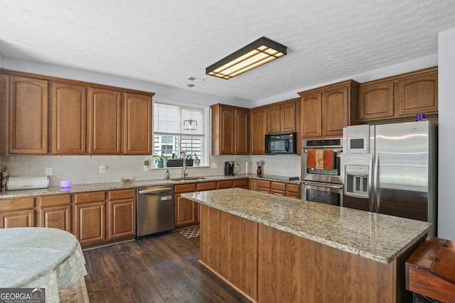 35 Timber Ln, Newnan, GA 30265 - kitchen with black appliances, dark wood finished floors, light stone countertops, a kitchen island, and a textured ceiling
