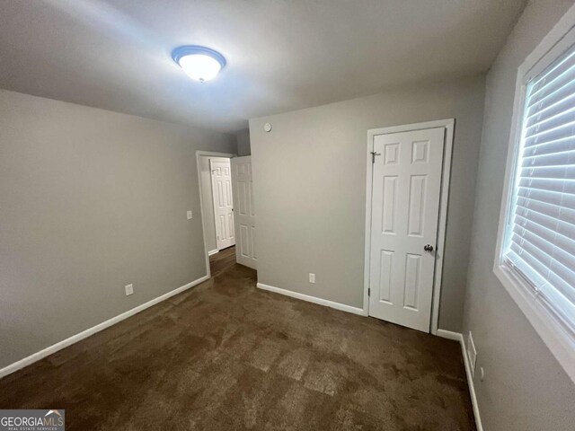 1263 Shoreham Dr, Atlanta, GA 30349 - unfurnished bedroom featuring baseboards and dark carpet