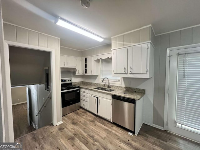 1263 Shoreham Dr, Atlanta, GA 30349 - kitchen with under cabinet range hood, a sink, wood finished floors, stainless steel appliances, and white cabinets