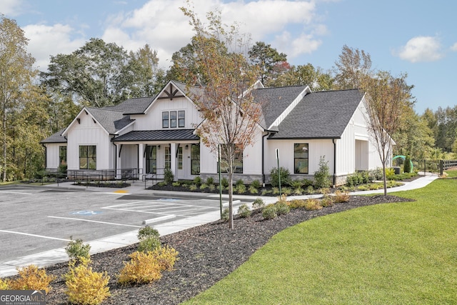 244 Oliver Dr, Locust Grove, GA 30248 - view of front of property with a front lawn, uncovered parking, covered porch, a standing seam roof, and board and batten siding