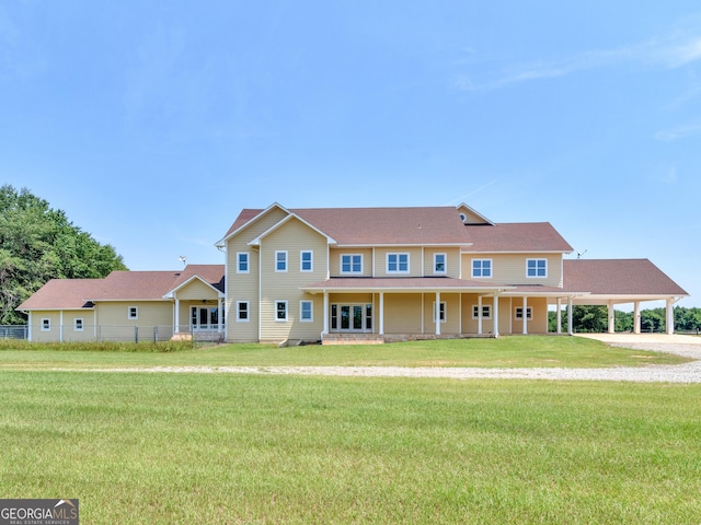 view of front of property featuring a front lawn, fence, and a carport