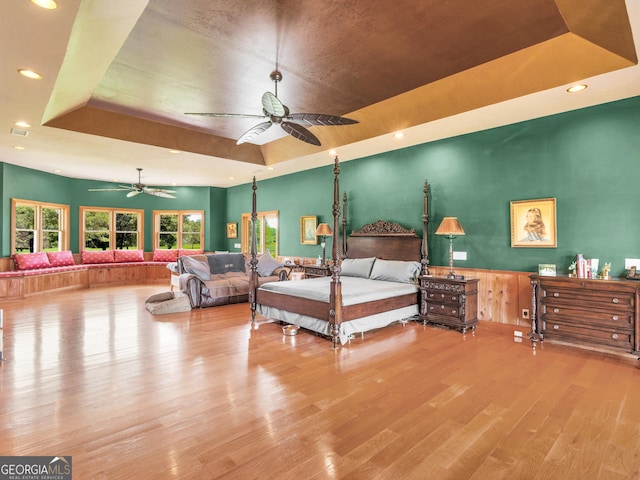 bedroom with a raised ceiling, recessed lighting, and wood finished floors