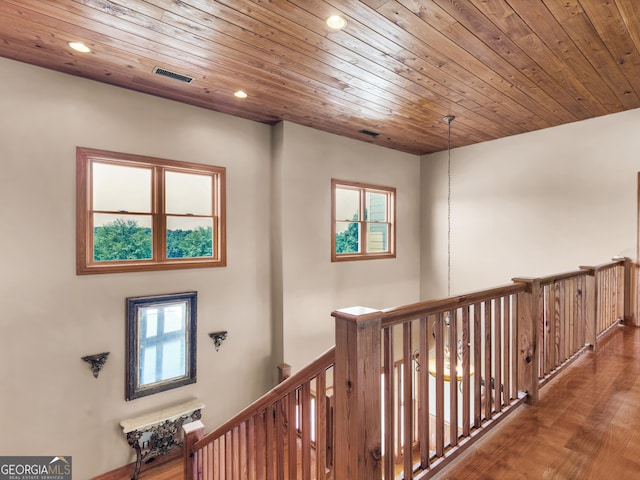corridor featuring recessed lighting, an upstairs landing, wood finished floors, and wooden ceiling
