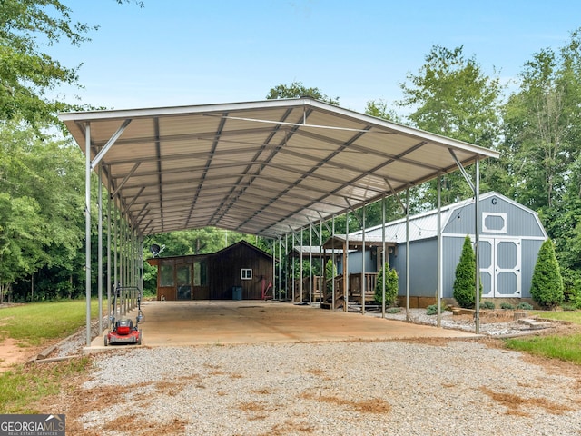 view of parking with gravel driveway, a storage unit, and a carport