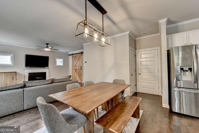 6468 Pierless Ave, Sugar Hill, GA 30518 - dining area featuring crown molding, ceiling fan, a barn door, and dark wood-type flooring