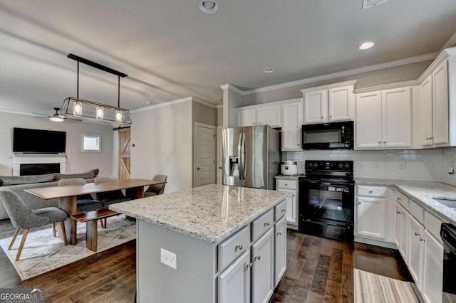 6468 Pierless Ave, Sugar Hill, GA 30518 - kitchen featuring crown molding, dark wood-style flooring, a kitchen island, open floor plan, and black appliances