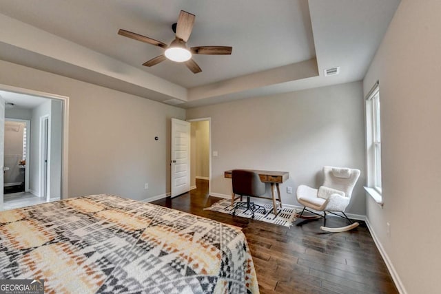 6468 Pierless Ave, Sugar Hill, GA 30518 - bedroom featuring visible vents, dark wood finished floors, baseboards, and a tray ceiling