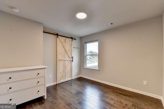 6468 Pierless Ave, Sugar Hill, GA 30518 - unfurnished bedroom with baseboards, visible vents, a barn door, and dark wood-type flooring