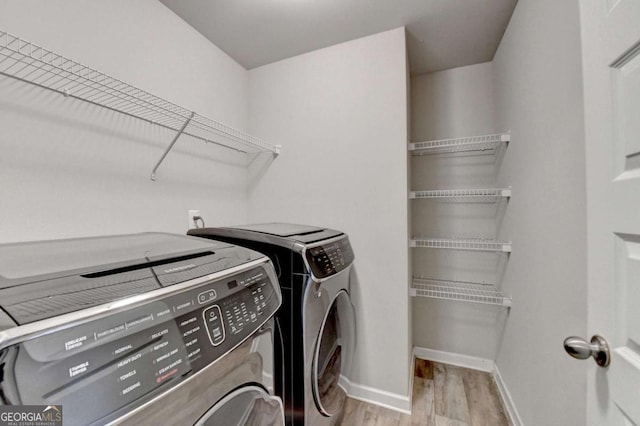 6468 Pierless Ave, Sugar Hill, GA 30518 - clothes washing area featuring washing machine and clothes dryer, laundry area, baseboards, and light wood-type flooring
