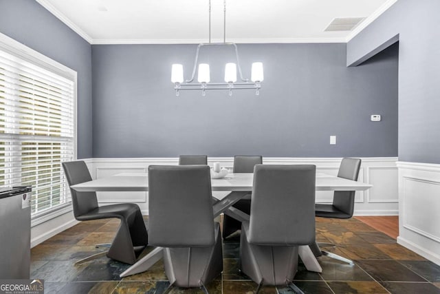 dining space with ornamental molding, a notable chandelier, and a wealth of natural light