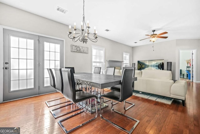 dining room featuring visible vents, ceiling fan with notable chandelier, and hardwood / wood-style floors