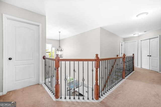 corridor featuring carpet flooring and an upstairs landing