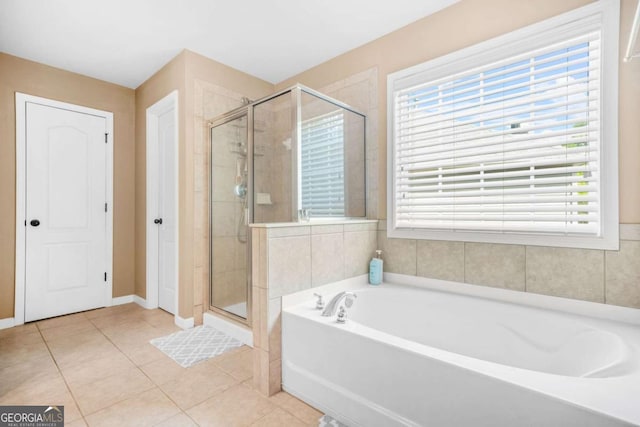 bathroom featuring baseboards, tile patterned floors, a bath, and a shower stall
