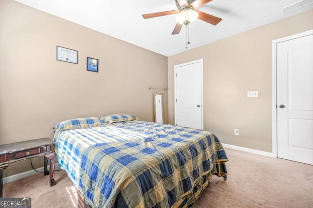 bedroom featuring baseboards, visible vents, ceiling fan, and light colored carpet