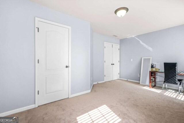 interior space with baseboards and carpet