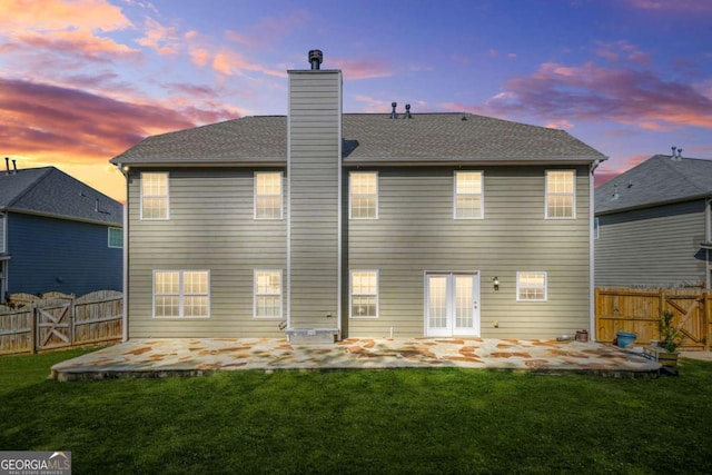 rear view of property featuring a lawn, a gate, a patio area, and a fenced backyard