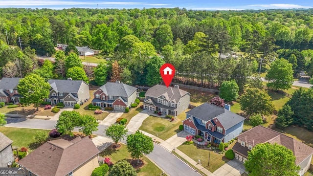 drone / aerial view featuring a view of trees and a residential view
