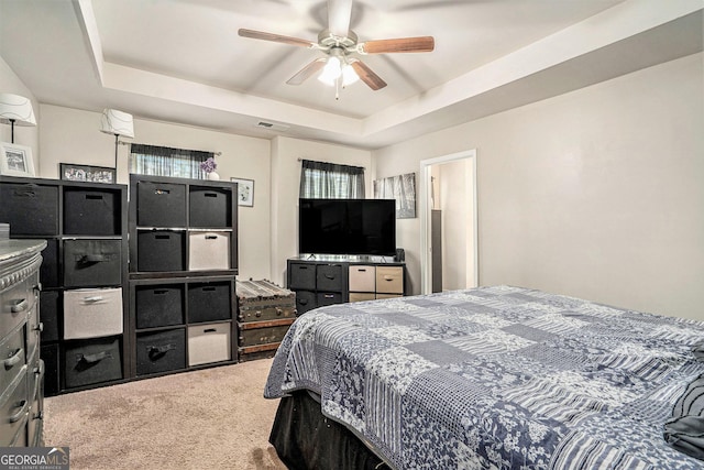 bedroom featuring ceiling fan, a raised ceiling, carpet flooring, and visible vents