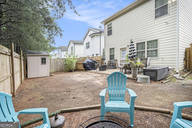 rear view of property featuring a fenced backyard, a patio area, an outbuilding, and a storage shed