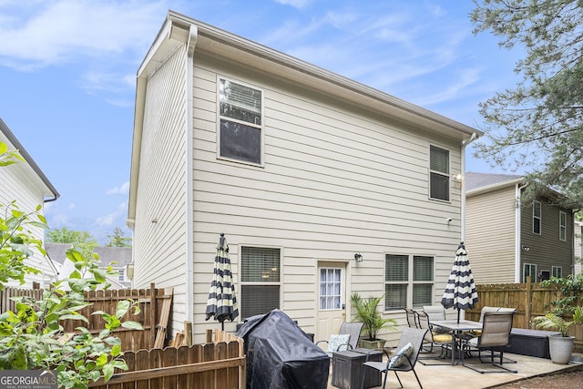 rear view of property with a fenced backyard and a patio area