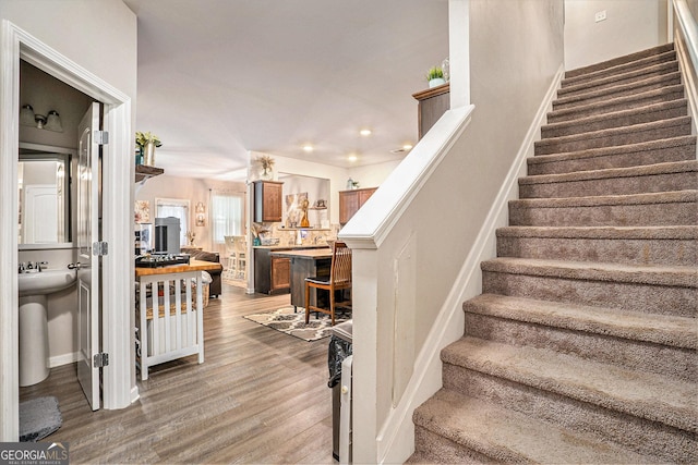 staircase featuring baseboards, recessed lighting, and wood finished floors