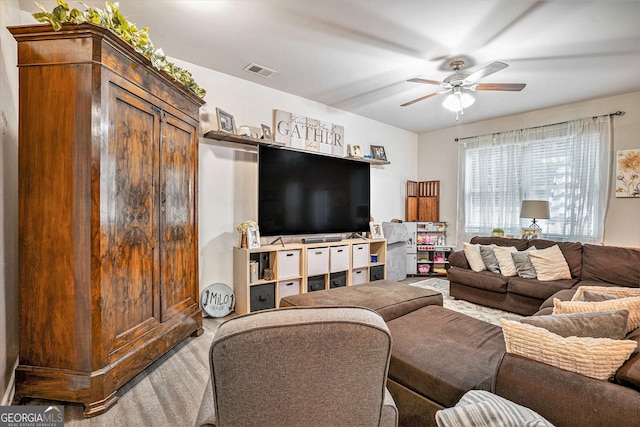 living area featuring a ceiling fan, visible vents, and wood finished floors