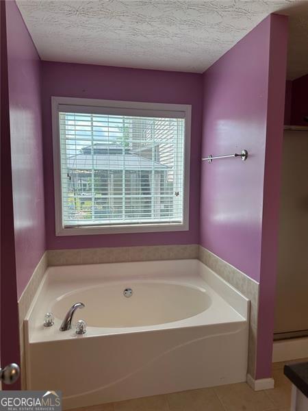 3218 Watson Woods Way, Loganville, GA 30052 - bathroom with tile patterned floors, a garden tub, and a wealth of natural light