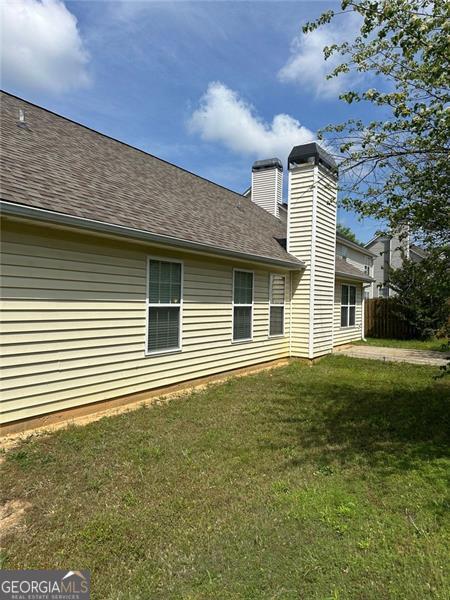 3218 Watson Woods Way, Loganville, GA 30052 - back of property featuring a lawn, roof with shingles, and a chimney