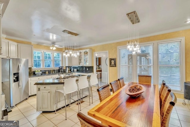 kitchen featuring glass insert cabinets, light tile patterned floors, a breakfast bar, and stainless steel appliances