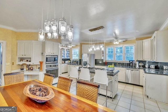 kitchen featuring a healthy amount of sunlight, light tile patterned floors, ceiling fan, and stainless steel appliances