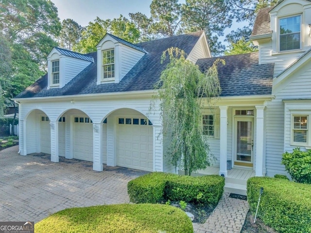 view of front of property featuring a porch, an attached garage, driveway, and a shingled roof