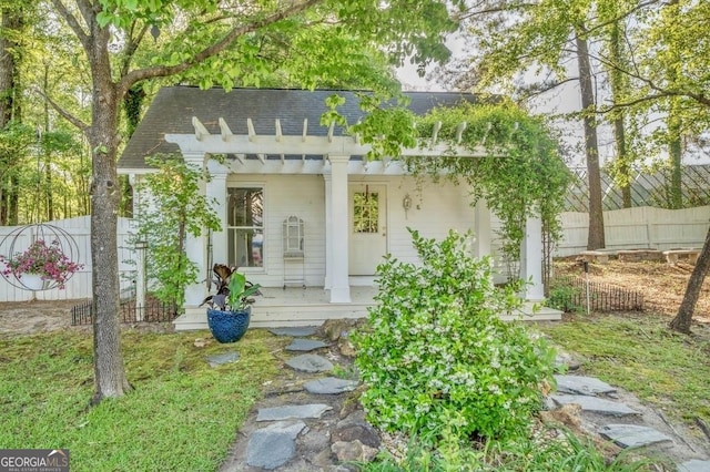 view of outbuilding with a porch and fence