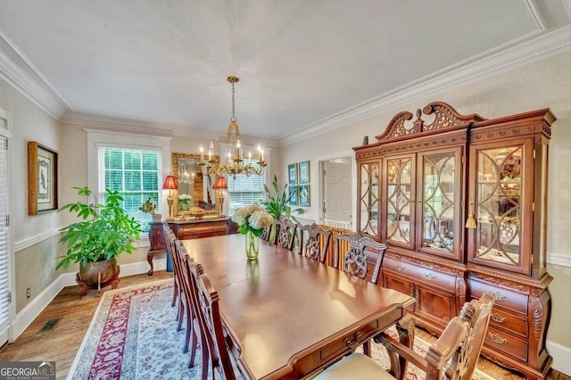 dining space featuring crown molding, visible vents, a notable chandelier, and light wood finished floors