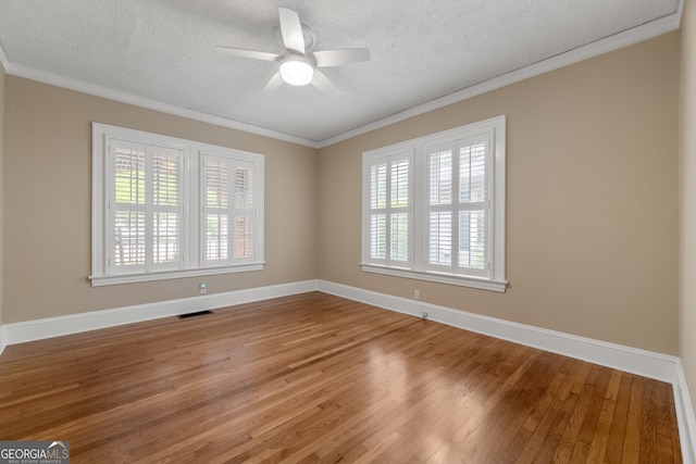 spare room with visible vents, wood finished floors, baseboards, a textured ceiling, and a ceiling fan