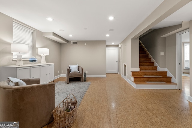 living area with visible vents, recessed lighting, stairs, and baseboards